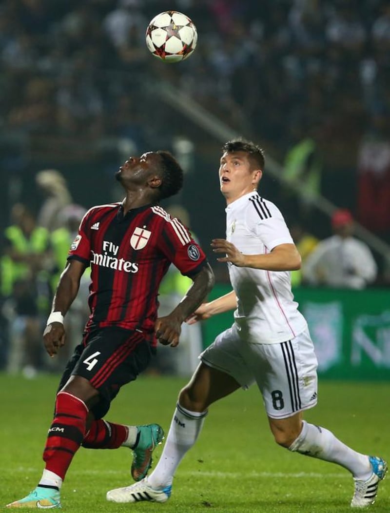 Toni Kroos (R) of Real Madrid vies for the ball against Sulley Ali Muntari of AC Milan during their world club friendly football match at the Sevens Stadium in Dubai on December 30, 2014. AC Milan won the match 4-2. AFP PHOTO / MARWAN NAAMANI