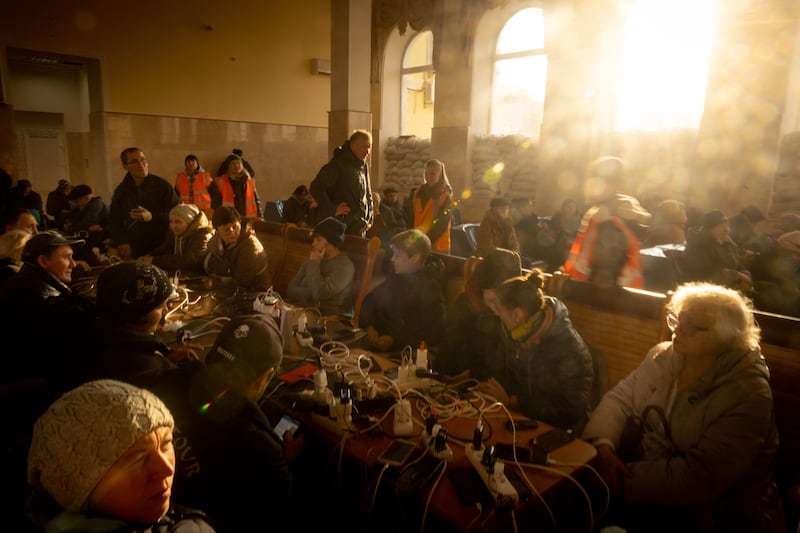 People wait as their electronic devices charge at the main railway station in Kherson, a city in which power is in short supply. Getty