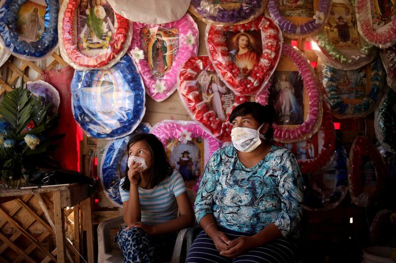 Rosa Leyva, right, and her nephew Viridiana wait for customers at her stall where she sells plastic flower arrangements and religious images, outside the San Rafael cemetery, in Ciudad Juarez, Mexico. Reuters