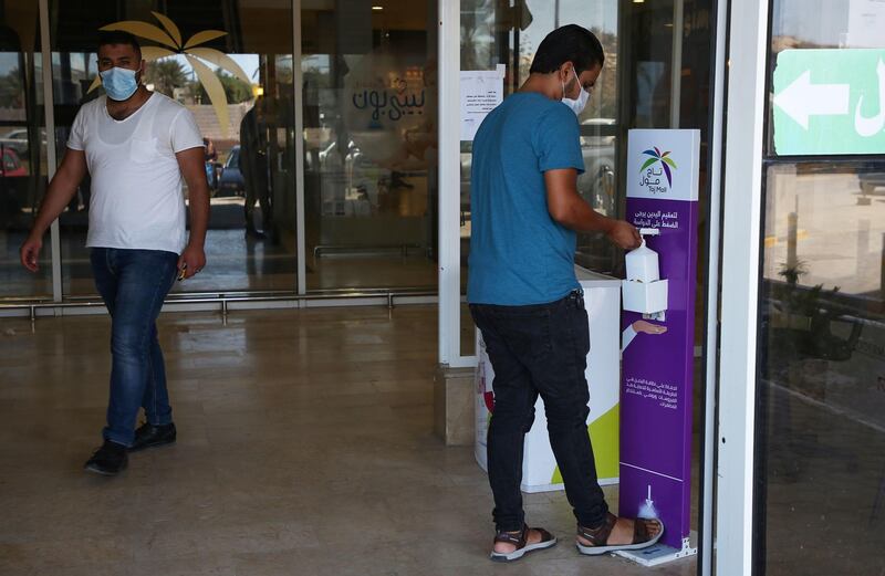 A man uses disinfecting gel at the entrance of a shop in the Libyan capital Tripoli.   AFP