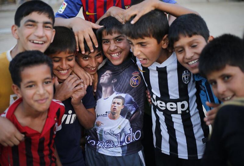 Iraqi Shi’ite boys, who play soccer, pose for a picture in Sadr City.