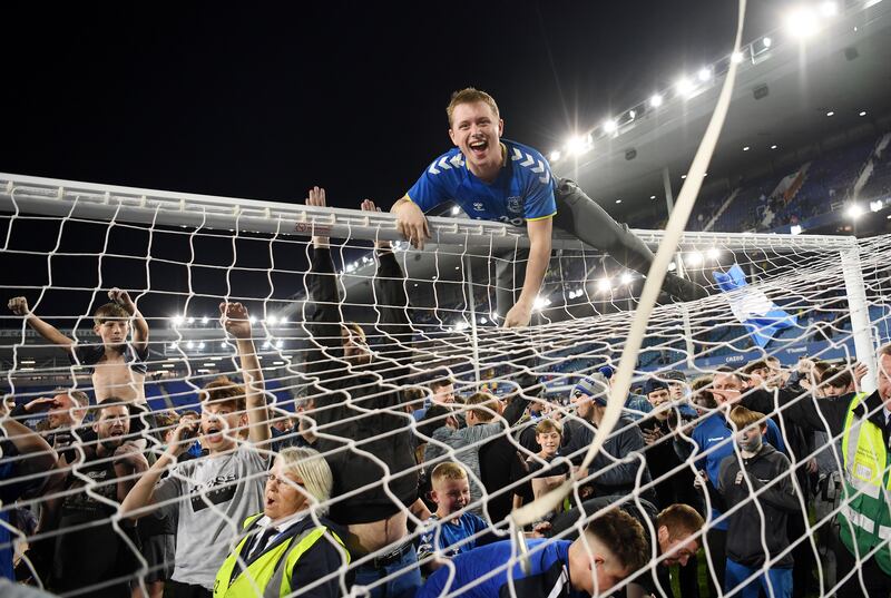 Everton fans celebrate on the pitch at Goodison Park in Liverpool after their side snatched victory from the jaws of defeat, coming from 2-0 down against Crystal Palace to win 3-2 and avoid relegation from the Premier League. Getty Images