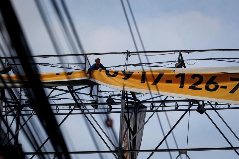 A worker removes an advertisement in preparation for typhoon Goni in Pasay City. EPA