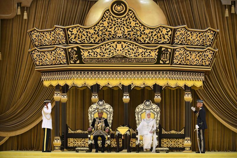 Malaysia's King Sultan Abdullah and Queen Tunku sit on the throne at the National Palace in Kuala Lumpur. Malaysia Information Ministry via AP