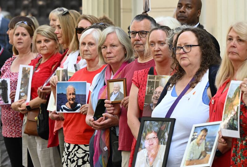 Members of the Covid-19 Bereaved Families for Justice group hold photos of relatives who died during the pandemic, as they demonstrate outside the venue of the UK Covid-19 inquiry, Dorland House in West London. AFP