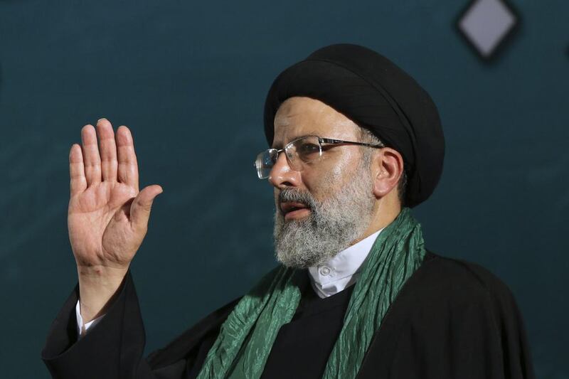 Iranian presidential candidate cleric Ebrahim Raisi waves to his supporters upon arrival at his campaign rally for the May 19 election at Imam Khomeini grand mosque in Tehran. Vahid Salemi / AP Photo