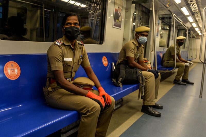 Police personnel travel on a trial run by maintaining social distancing during a media preview as the Chennai Metro prepares to resume services partially, at a metro station in Chennai.  AFP