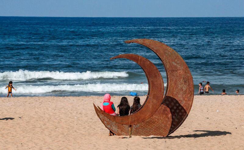 Syrian refugees sit and swim at a public beach in the Lebanese capital Beirut's Ramlet al-Baida neighbourhood. AFP