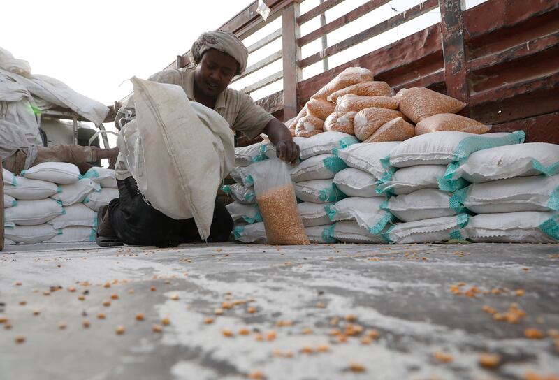 An aid worker prepares bags of beans to be distributed in Al Jarahi in the port province of Hodeidah, Yemen. EPA