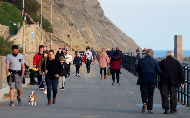 People walk along the promenade in Folkestone, Kent. AP Photo