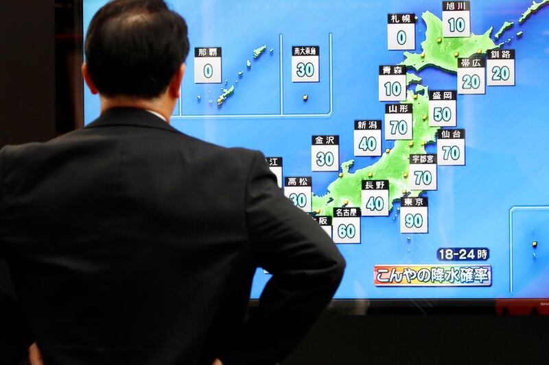 A man watches a public TV of weather forecast in Tokyo. AP