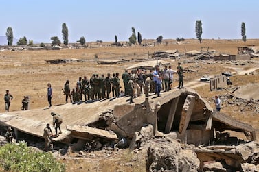 Syrian soldiers stand atop a destroyed building in the town of Quneitra on the Syrian side of the Golan Heights. Israeli and Syrian forces, the latter backed by Iran, are fighting a low level conflict in the area, which has escalated since 2018. AFP