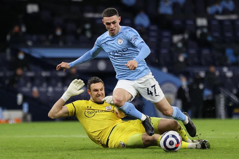 Southampton's English goalkeeper Alex McCarthy (L) and Manchester City's English midfielder Phil Foden in action during the English Premier League football match between Manchester City and Southampton at the Etihad Stadium in Manchester, north west England on March 10, 2021. RESTRICTED TO EDITORIAL USE. No use with unauthorized audio, video, data, fixture lists, club/league logos or 'live' services. Online in-match use limited to 120 images. An additional 40 images may be used in extra time. No video emulation. Social media in-match use limited to 120 images. An additional 40 images may be used in extra time. No use in betting publications, games or single club/league/player publications.
 / AFP / POOL / Clive Brunskill / RESTRICTED TO EDITORIAL USE. No use with unauthorized audio, video, data, fixture lists, club/league logos or 'live' services. Online in-match use limited to 120 images. An additional 40 images may be used in extra time. No video emulation. Social media in-match use limited to 120 images. An additional 40 images may be used in extra time. No use in betting publications, games or single club/league/player publications.
