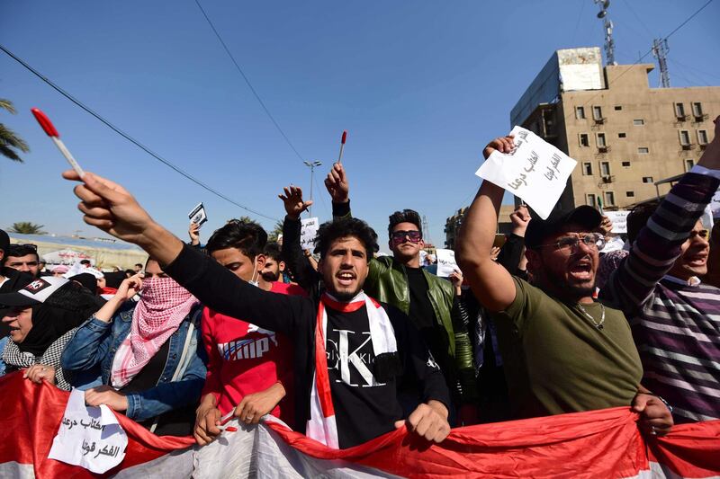 Iraqi university students hold up pens and shout slogans during a protest in central Baghdad, Iraq.  EPA