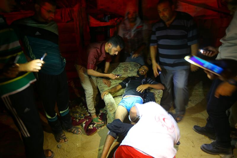 A Palestinian paramedic gives first aid to a wounded man following an Israeli air strike in Gaza City on June 27, 2017. Mohammed Abed / AFP Photo