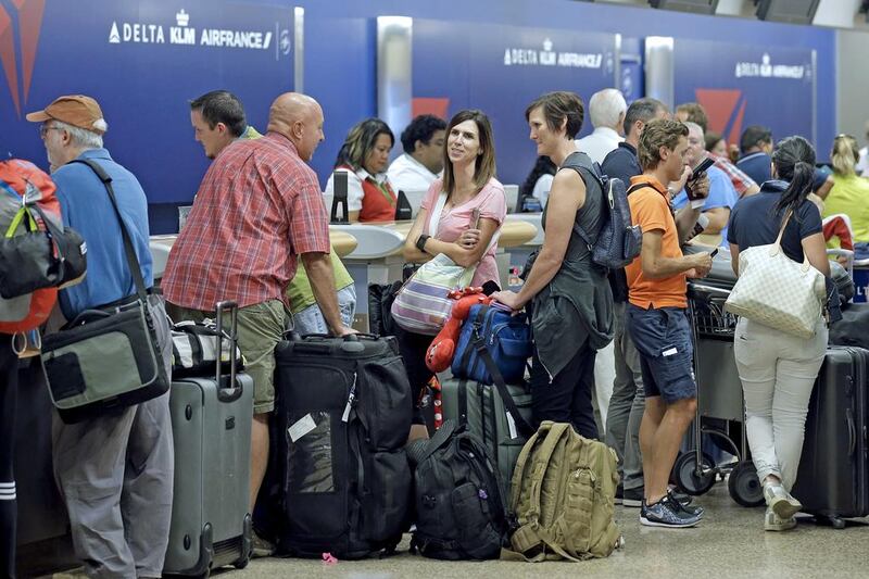 Passengers stand in line after Delta Air Lines flights resumed on Monday in Salt Lake City. Rick Bowmer / AP Photo
