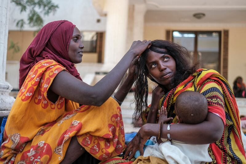 A woman gets her hair braided outside the Agda Hotel.