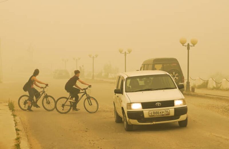 Cyclists ride through thick wildfire smoke in Yakutsk, Russia. Health chiefs are calling for action to protect both the planet and public health. Getty