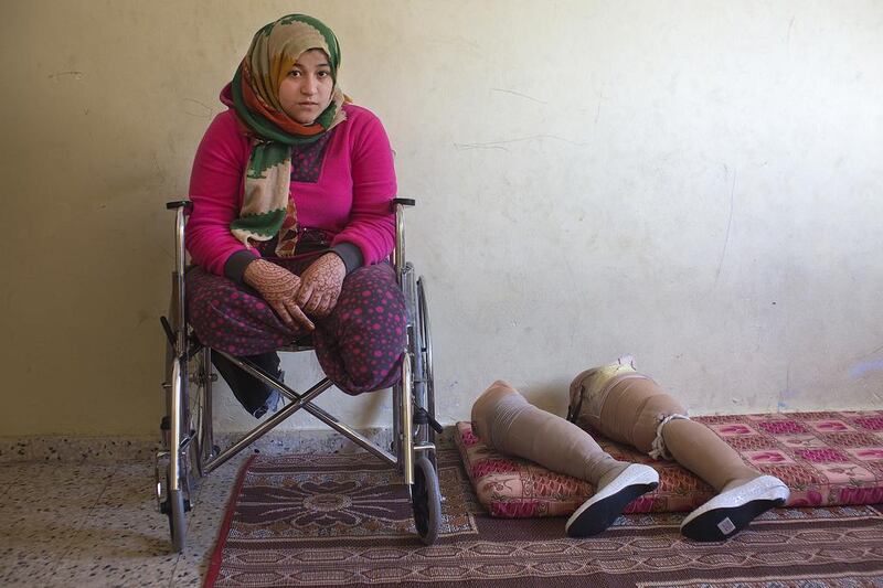 Palestinian Manar Shabari sits in her wheel chair by her   prosthetic legs that have been fitted with festive shoes to be worn at her brother’s wedding at a relative’s home  in Jabalya, Gaza December ,30,2014 . Manar Shabari,14, suffered severe injuries  on July 24 during an Israeli military assault on  the UN school in Beit Hanoun, in northern Gaza .Her mother and brother and three other family members were amongst the more than 15 killed at the school where  hundreds of displaced civilians were taking shelter during the war between Israel and Palestinian militants in the Hamas-controlled Gaza Strip . Heidi Levine for The National