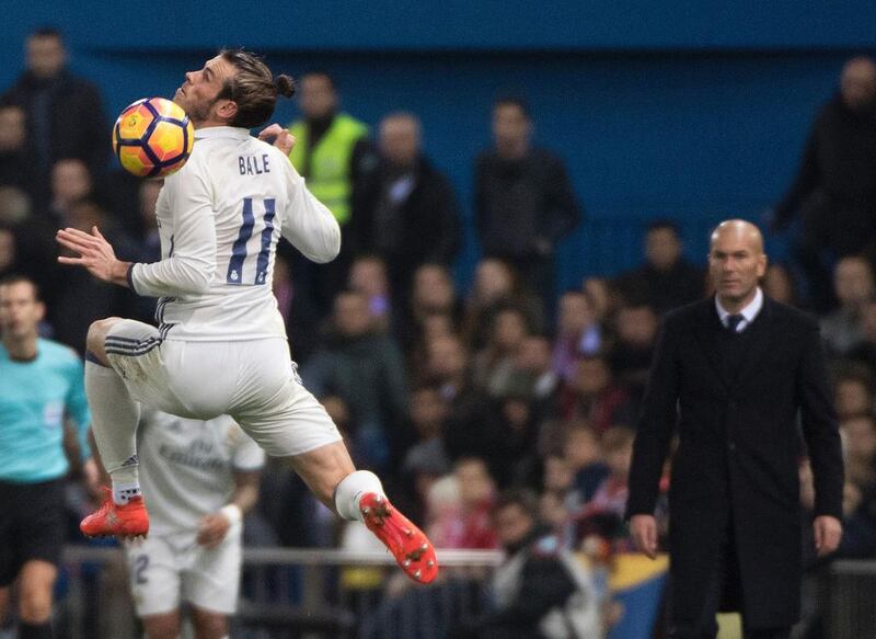 Real Madrid’s Welsh forward Gareth Bale, left, jumps with the ball. Curto de la Torre / AFP