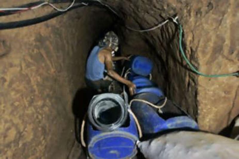 A Palestinian man receives goods from Egypt through a tunnel dug 15 meters underneath the border in Rafah refugee camp.