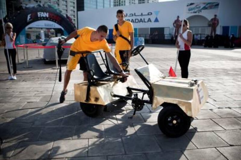 November 7, 2010, Abu Dhabi, UAE: 

The F1 Fanzone on the Corniche next to 30th street held a push petal competition. Schools from the area (ranging from secondary schools to universities) had teams of students design push petal cars which were then judged to detemrine winners in three categories (best urban design, best racing design, and most outrageous).

Members of the Rub Al Khali School's team, The Falcons, show off their car to the judges. 
Lee Hoagland/ The National