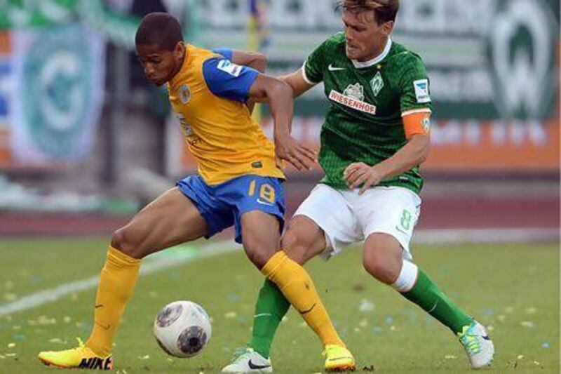 Braunschweig's Simeon Jackson, left, and Bremen's Clemens Fritz tussle for the ball. Peter Steffen / AFP