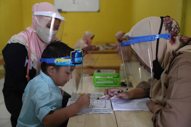 Teachers and students wear protective gear as a precaution against the coronavirus outbreak during a class at a Quran educational facility at on the outskirts of Jakarta, Indonesia. AP Photo