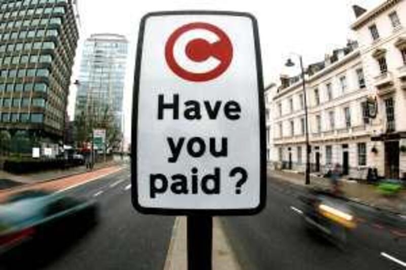 A congestion charge pay reminder sign is seen in London February 19, 2007. The western extension to the London congestion charging zone comes into force on Monday and will cost 8 pounds ($15.6) per day. REUTERS/Alessia Pierdomenico (BRITAIN)