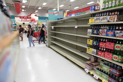 Customers walk near empty shelves that are normally filled with bottles of water after Puerto Rico Governor Ricardo Rossello declared a state of emergency in preparation for Hurricane Irma, in San Juan, Puerto Rico September 4, 2017. REUTERS/Alvin Baez