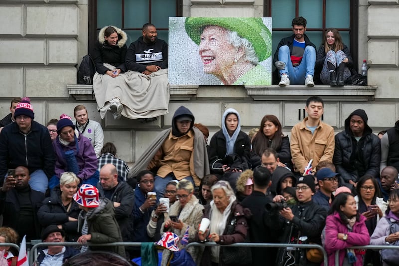 People waiting along the route that the coffin will be pulled on a gun carriage in central London. AP