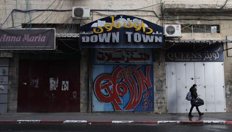 A woman walks past closed shops in Jerusalem as a general strike was called following US President Donald Trump's decision to recognise Jerusalem as the capital of Israel, on December 7, 2017 in east Jerusalem.  / AFP PHOTO / Ahmad GHARABLI