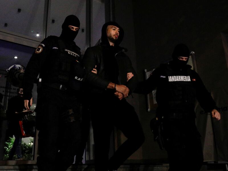 Andrew Tate is escorted by police officers in Bucharest, Romania, after his arrest. Reuters