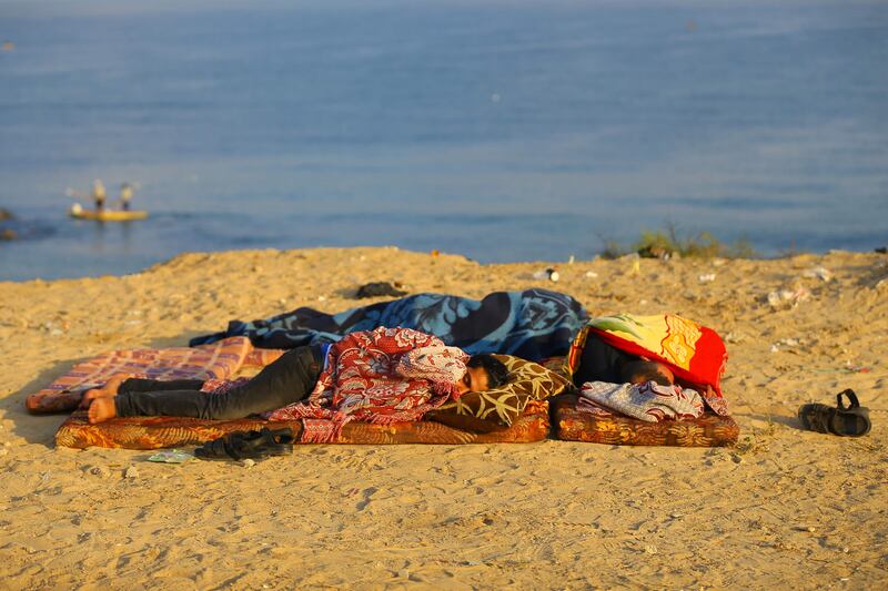 Palestinians sleep by the sea near a Hamas base (unseen) targeted by Israeli warplanes in Gaza City on August 9, 2017
Three people were injured, including one critically, overnight as Israel bombed Hamas sites in the Gaza Strip, Palestinian security and medical sources said, hours after a rocket hit the Jewish state. The Israeli army confirmed the strikes, saying they were in retaliation for a rocket fired a few hours earlier from Gaza, which landed in southern Israel. / AFP PHOTO / MOHAMMED ABED