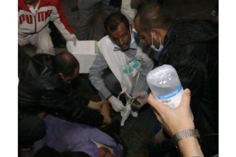 Medics treat an injured anti-government protester at a makeshift clinic outside Sana'a University.