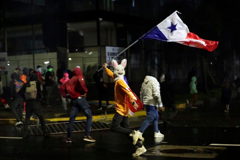 A protester runs amid clashes with police during a march against copper mining in Panama City. EPA