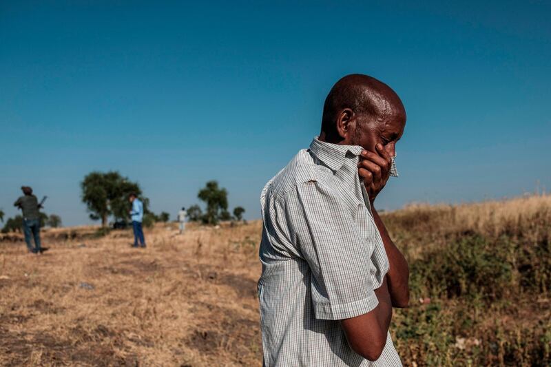 A man reacting as he stands near a ditch in the outskirts of Mai Kadra, Ethiopia, that is filled with more than 20 bodies of victims that were allegedly killed in a massacre on November 9, 2020. AFP