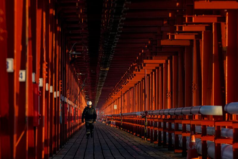 A worker walks inside the chemical company Oxiquim, which was shut down due to pollution in coastal communities, in Quintero Bay, Chile. AP