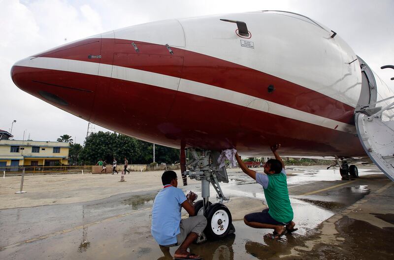 Members of the Nepali Army clean mud off an airplane left after flood hit parts of Biratnagar's domestic airport in Morang district, Nepal. NARENDRA SHRESTHA / EPA
