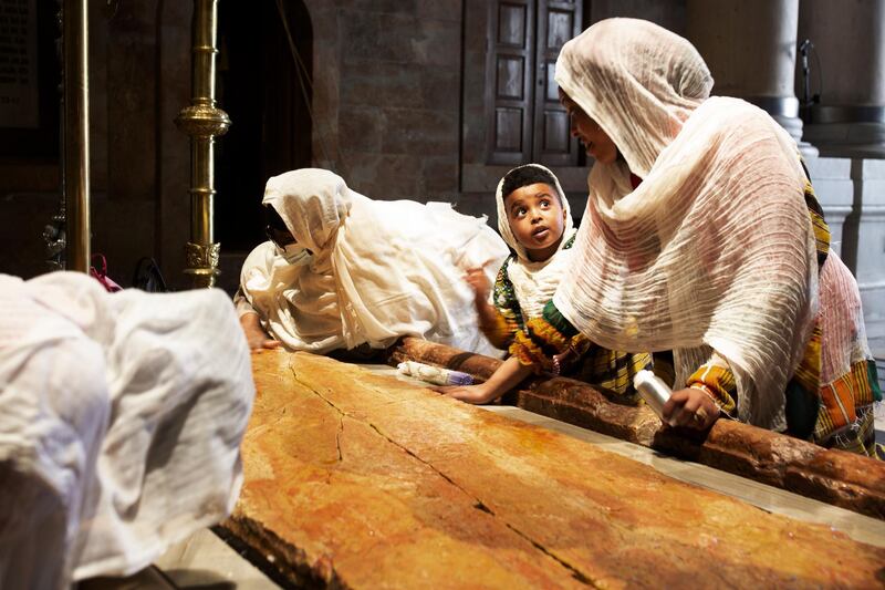 A child visits the Stone of Unction with her mother at the Church of Holy Sepulchre, in the Old City of Jerusalem, where many Christians believe Jesus was crucified, buried and rose from the dead. AP Photo