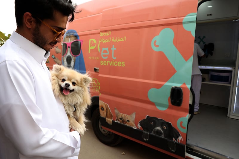 A Saudi customer and his dog wait their turn outside a pet-grooming van in Riyadh. AFP