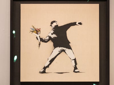 Banksy's "Love is in the Air" displayed during "The Now Evening Auction" at Sotheby's auction house in New York on November 18, 2021. AFP