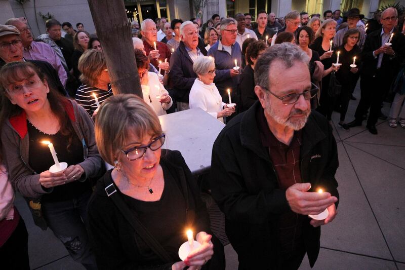 People from the community join members of the Rancho Bernardo Community Presbyterian Church in a candlelight vigil for the Chabad of Poway synagogue shooting victims in the Rancho Bernardo neighborhood of San Diego, California, Saturday, April 27, 2019. The San Diego Union-Tribune via AP