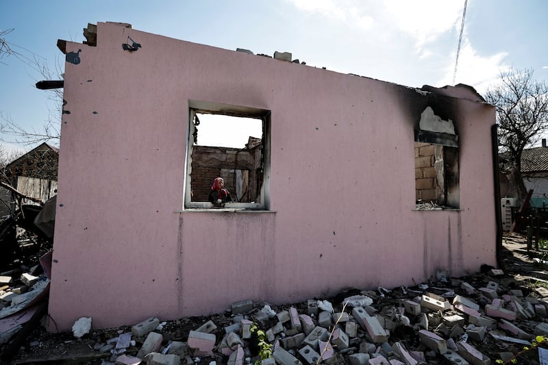 A woman stands near her house that was destroyed by shelling in Sloboda, Chernihiv region, Ukraine. Reuters