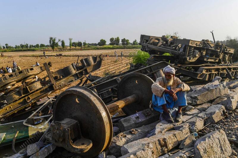 A railway worker rests next to the wreckage of a train. AFP