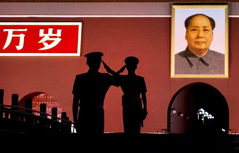 Chinese Paramilitary police officers salt each other as they stand guard below a portrait of the late leader Mao Zedong in Tiananmen Square in Beijing, China. Kevin Frayer / Getty