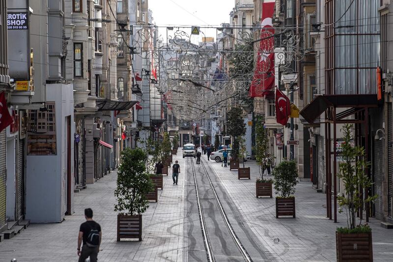 People walk in the almost-deserted Istiklal street at Taksim district in Istanbul during a four-day curfew to prevent the spread of Covid-19. AFP