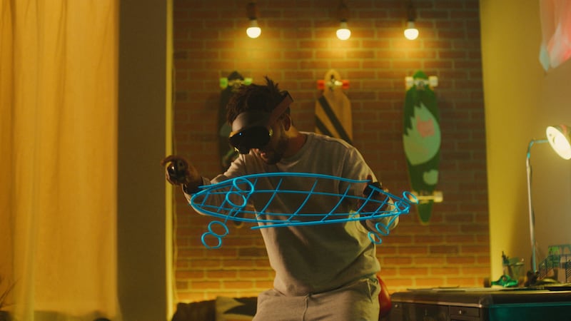 A man wearing a Quest Pro headset interacts with a 3D virtual drawing of a skateboard. Reuters