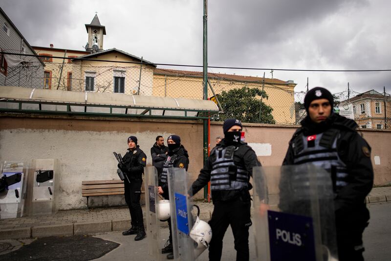 Turkish police officers stand guard in a cordoned off area outside the Santa Maria church, in Istanbul, Turkey, Sunday, Jan.  28, 2024.  Two masked assailants attacked a church in Istanbul during Sunday services, killing one person, Turkish officials said.  (AP Photo / Emrah Gurel)