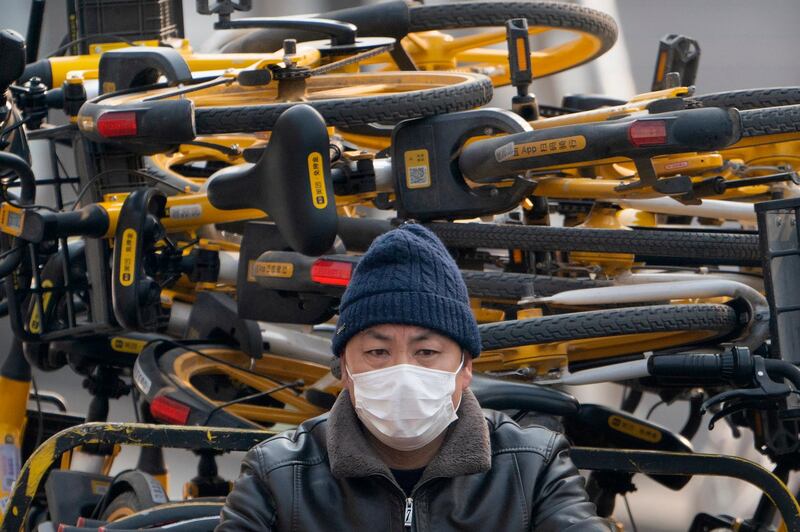 A worker drives a cart loaded with rental bicycles in Beijing, China. AP Photo